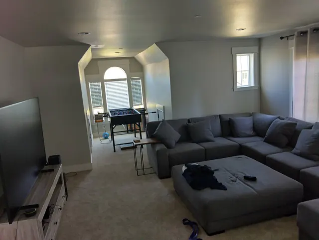 Restored second-floor family room with sectional sofa and new carpet
